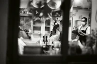 a black and white photo of people in a barber shop