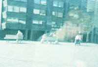 a person sitting on a bench in front of a building