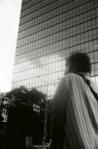 a person is standing in front of a tall building