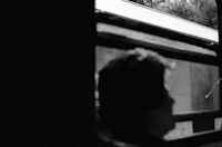 a person looking out the window of a train